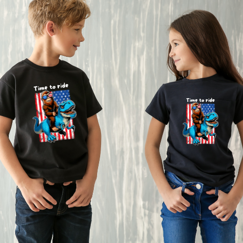 Youth BigFoot on a Dinosaur Shirt | Patriotic Sasquatch Shirt for Kids | Youth Yeti Short Sleeve Tee | Funny BigFoot shirt for boys | Bella Canvas Soft Cotton tee shirt